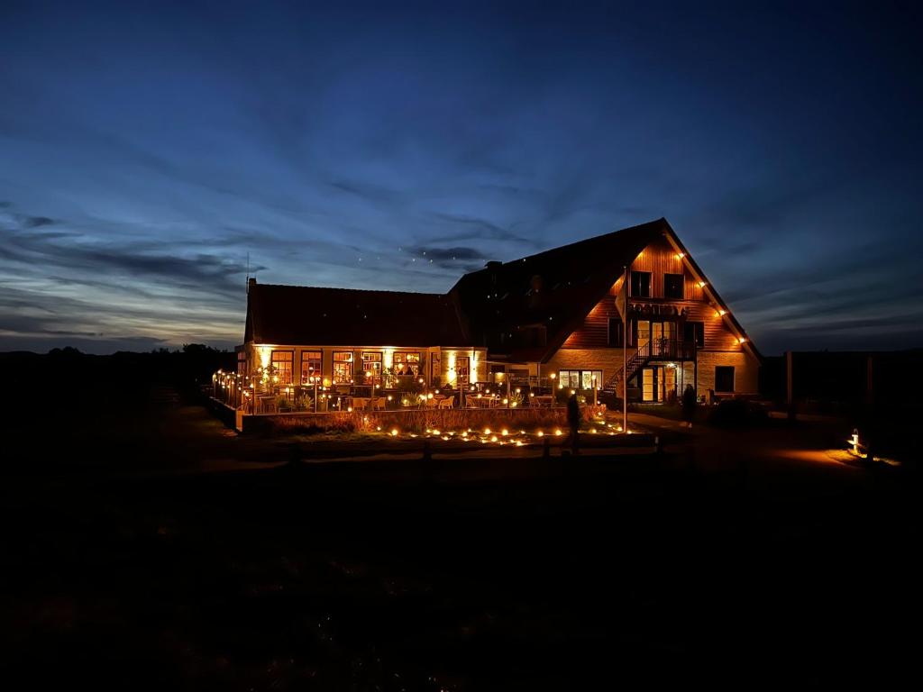 东弗利兰Hotel Posthuys Vlieland的夜间亮着灯的谷仓
