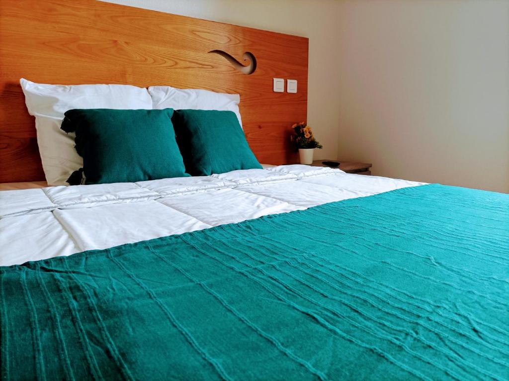 MourjouAuberge de Mourjou的一张绿色和白色的床,配有木制床头板