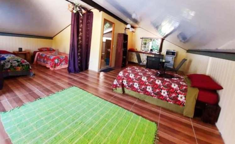 乌图罗阿Studio Rava 1 Room Fare Tepua Lodge的一间带两张床的卧室和绿色地毯