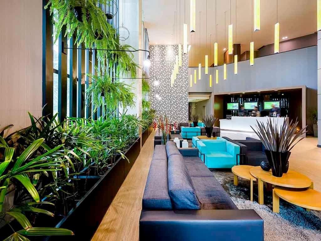 巴西利亚Apartamento em hotel 5 Estrelas Brasília - GMB0414的大堂设有蓝色椅子和盆栽植物