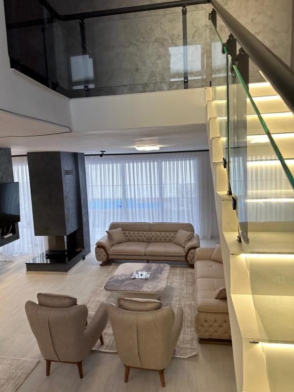 OrllanLuxury Villa’s的带沙发和椅子的客厅以及楼梯。