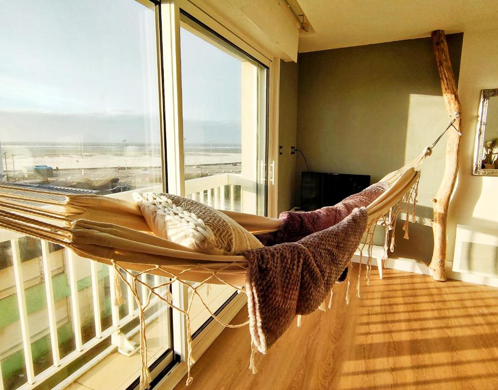 滨海贝尔克Hamac chic vue mer.的带大窗户的客房内的吊床