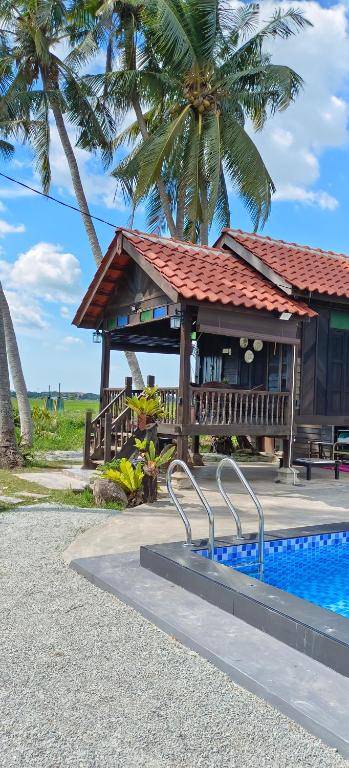 PenagaKampung Cheq Homestay - Private Pool, Free Wifi, Netflix的一座带游泳池的度假村,位于一座建筑旁边