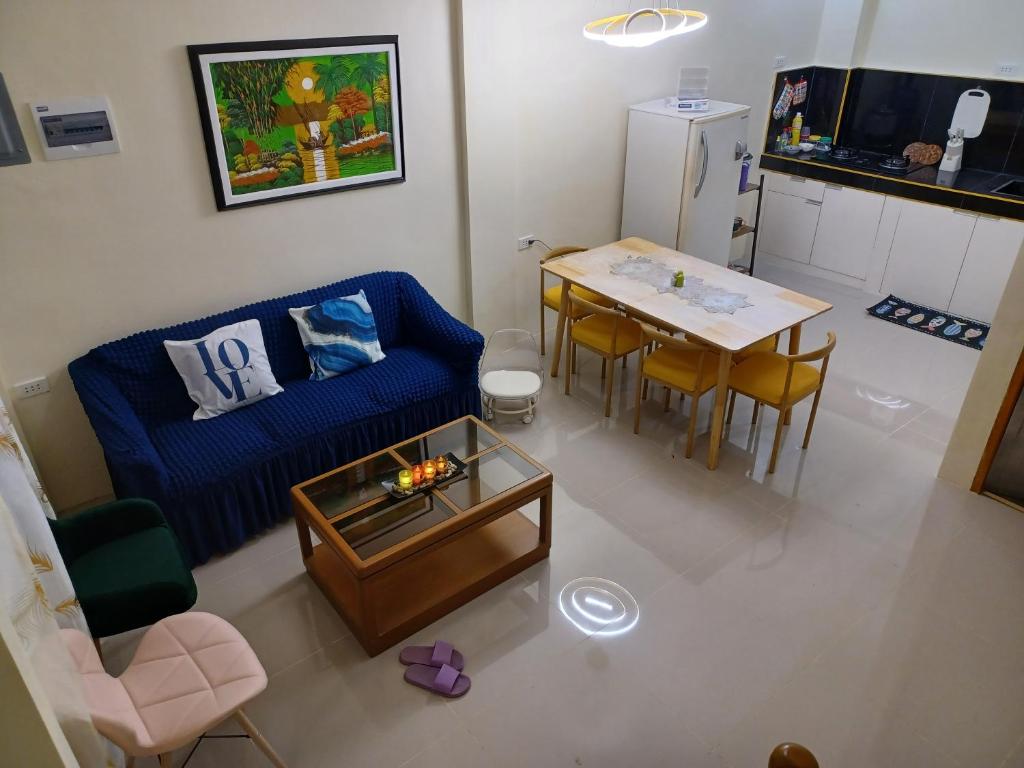 San RoqueCebu City 80sq Apartment near SM Seaside NuStar Ocean Park Dynamic Herb的客厅配有蓝色的沙发和桌子
