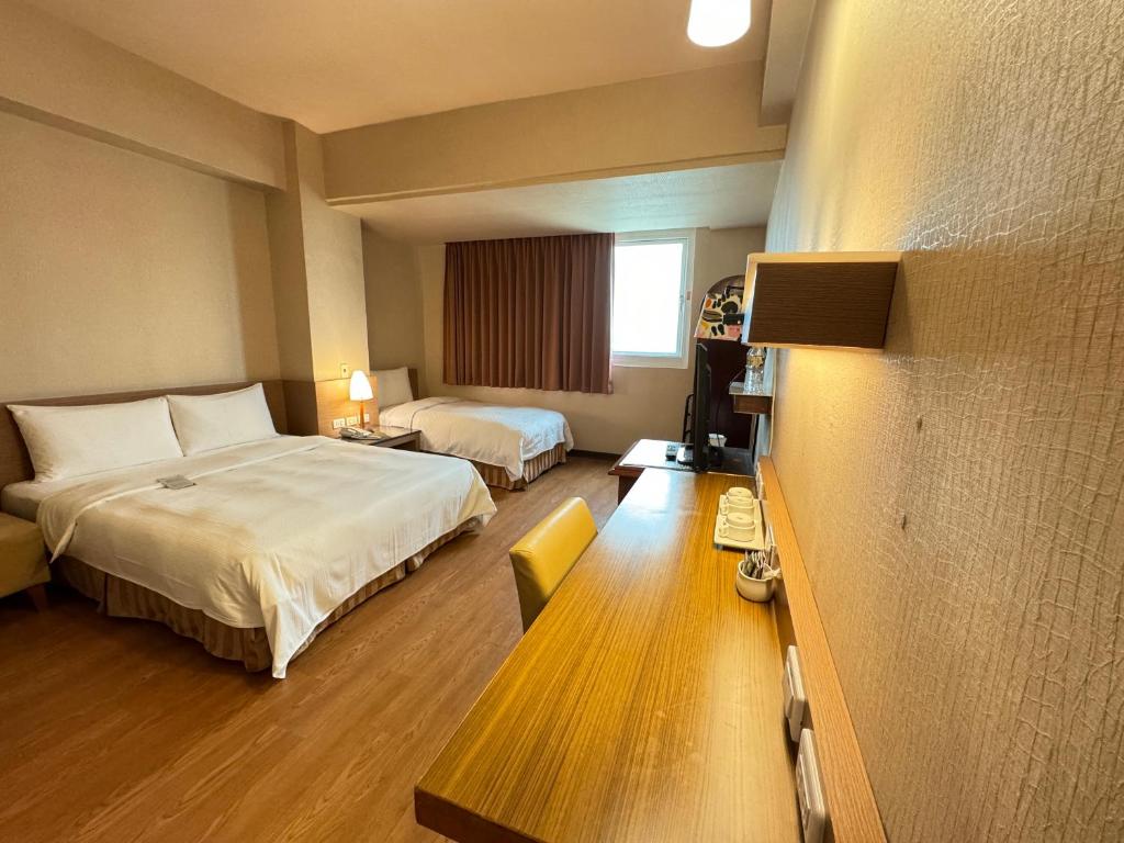 高雄康桥商旅五甲馆的酒店客房设有两张床和窗户。