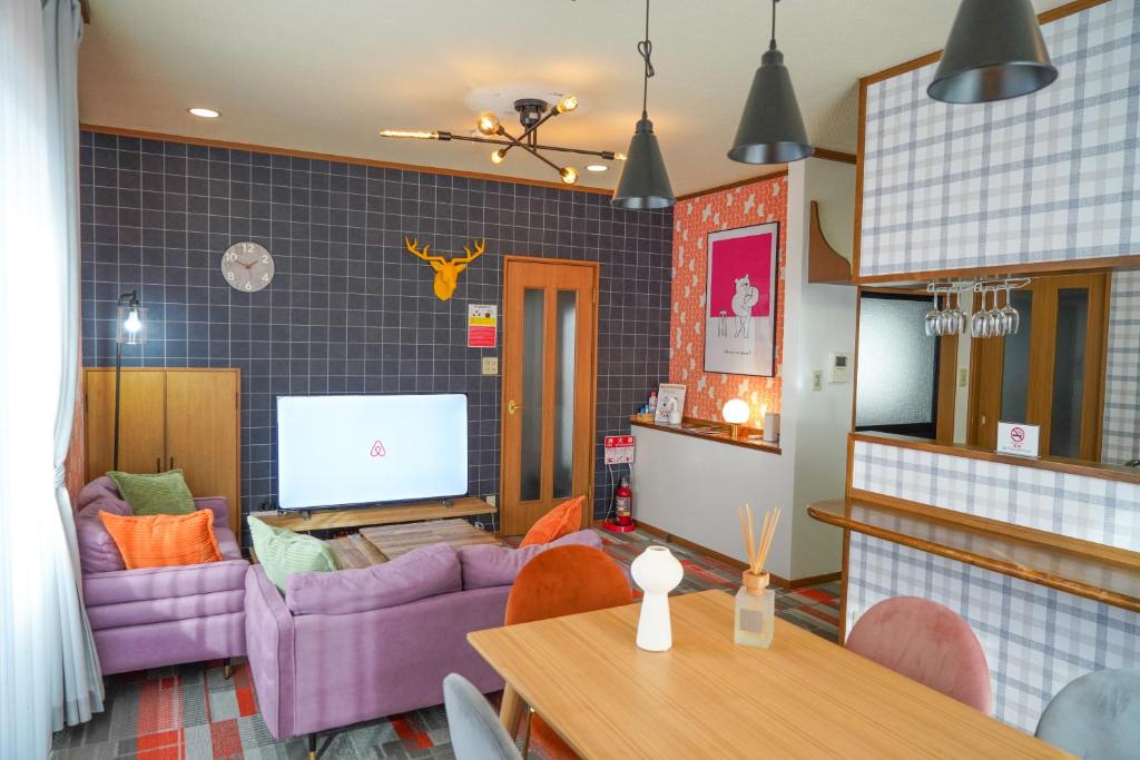 别府Living CUBE Beppu的客厅配有紫色沙发和桌子