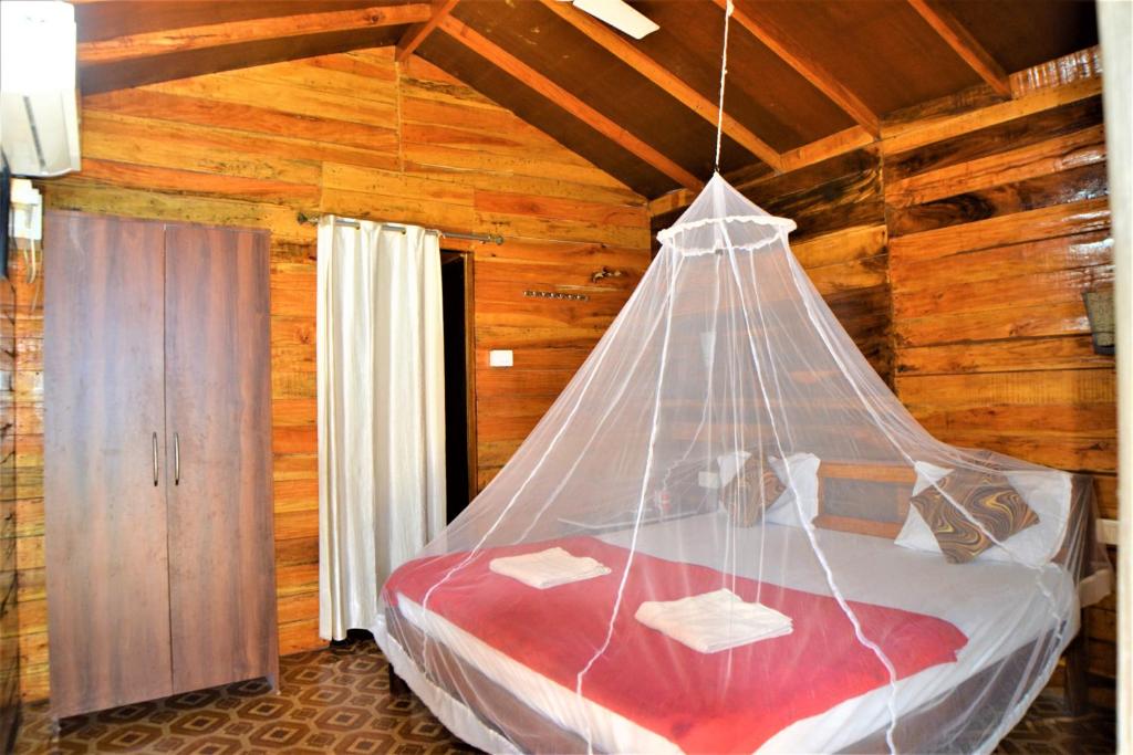 阿贡达Agonda Sun Set的一间卧室配有一张带蚊帐的床