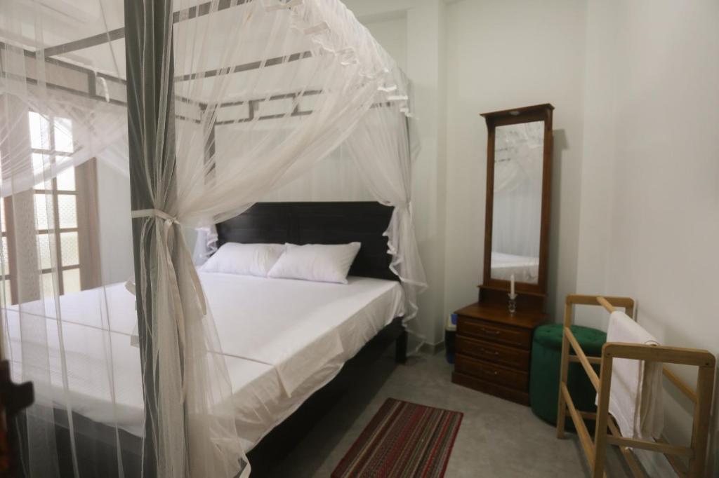 高尔cric villa的一间卧室配有天蓬床和镜子