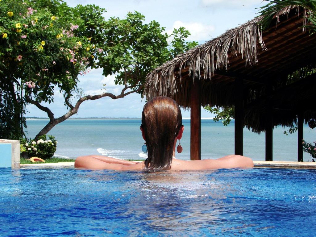 杰里科科拉杰里巴酒店的一位在游泳池里看着大海的女人
