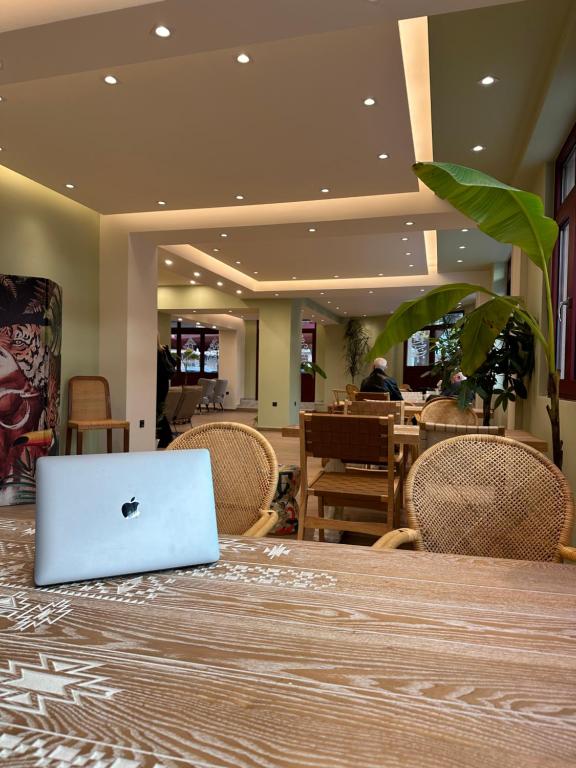 塞萨洛尼基The Maroon Bottle Luxury Suites的坐在餐厅桌子上的苹果笔记本电脑
