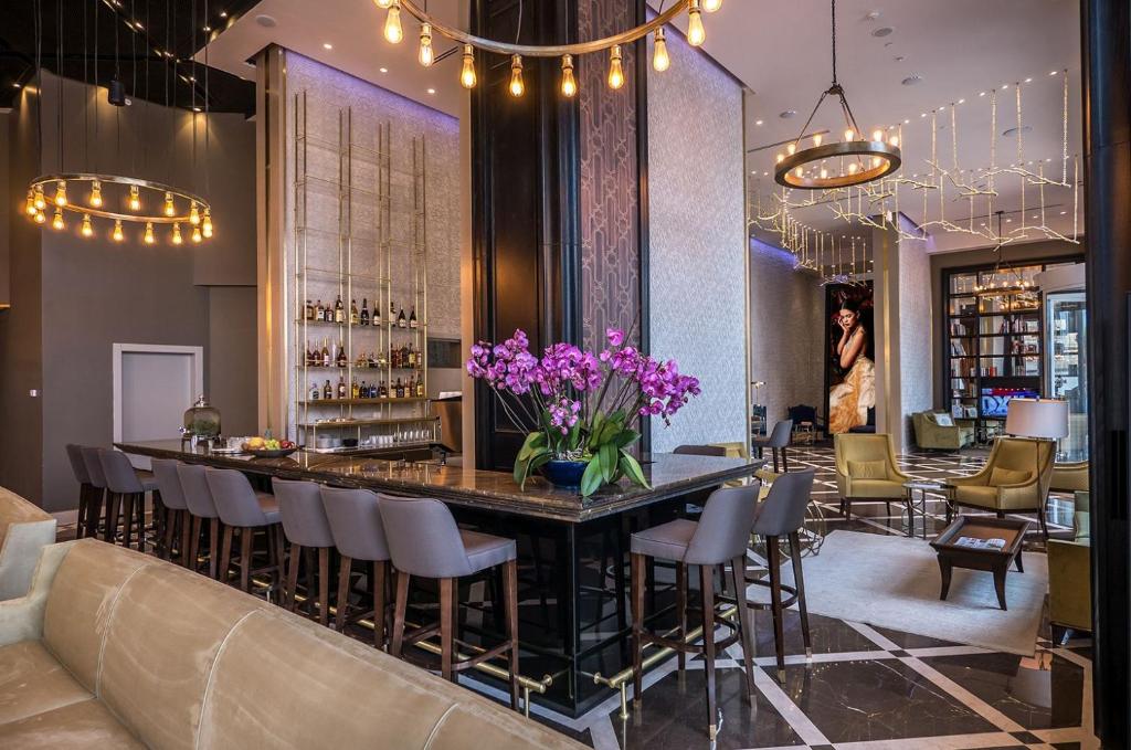 内坦亚David Tower Hotel Netanya by Prima Hotels - 16 Plus的餐厅的酒吧,在柜台上种有紫色花