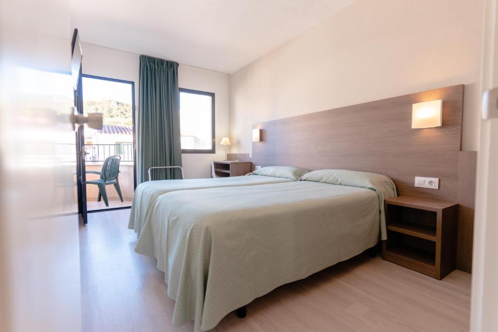费雷列斯罗阿尔公寓酒店的一间带大床的卧室和一个阳台