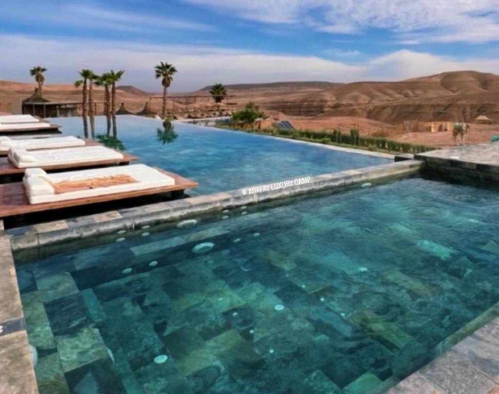 马拉喀什Agafay Luxury camp的享有沙漠景色的游泳池