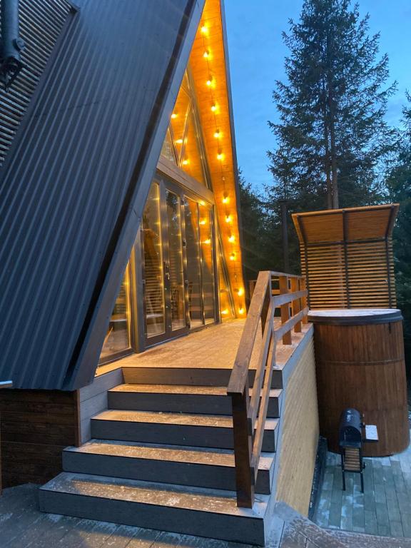 ZhurakyThe Sunset Cabin будиночок з Чаном的一座带楼梯的房子,通往一座带灯的建筑