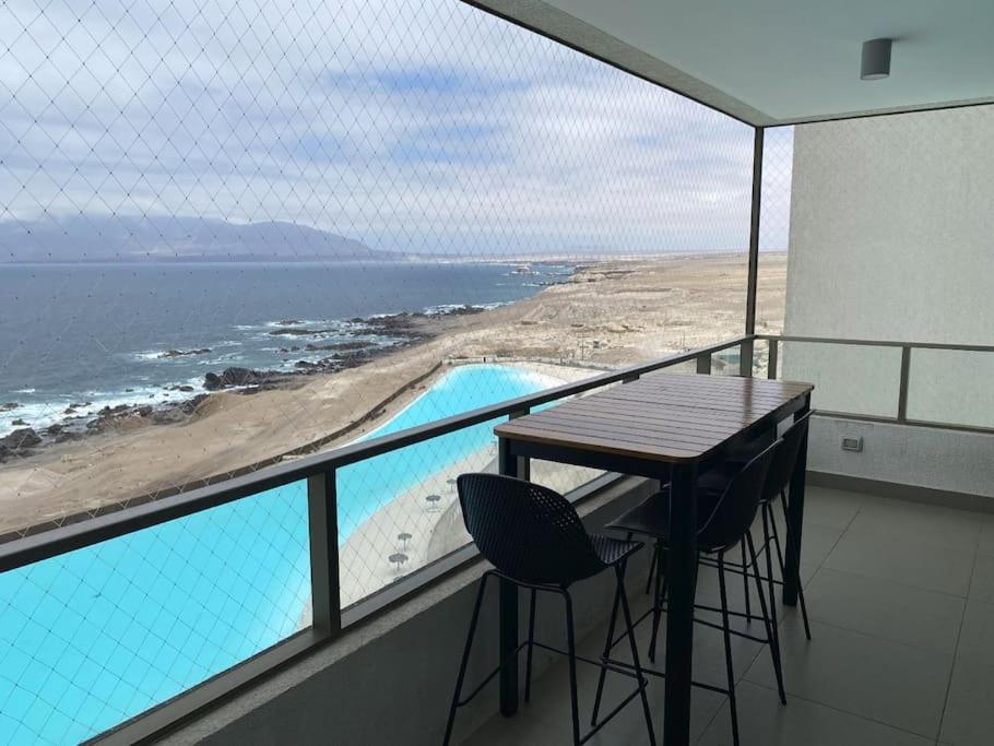 La ChimbaDepartamento Antofagasta. Playa privada的一个带桌椅的海景阳台