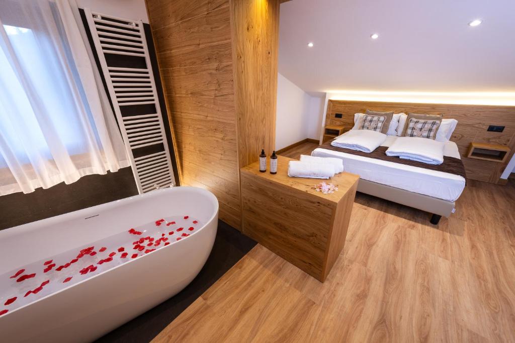 佩斯卡塞罗利艾瑞斯酒店的一间带浴缸、床和浴缸的卧室