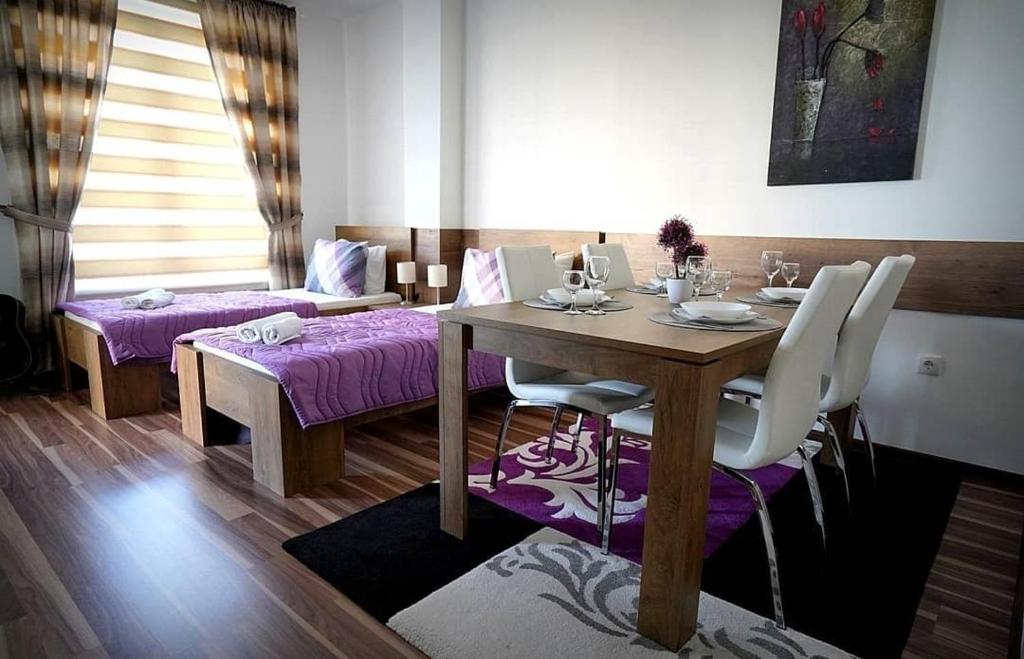 克拉多沃Serbona apartment的一间带木桌和紫色椅子的用餐室