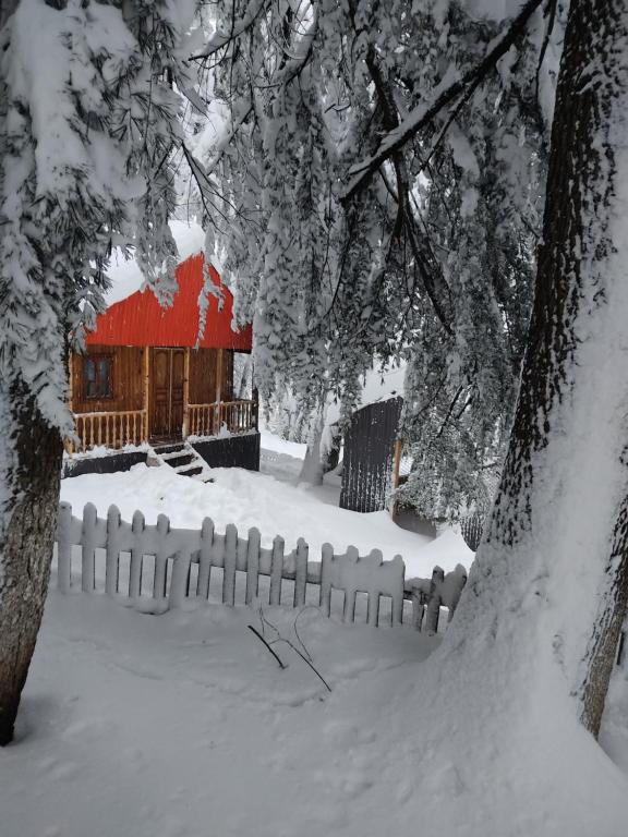 KhuloBarybari的雪中用红色谷仓围栏