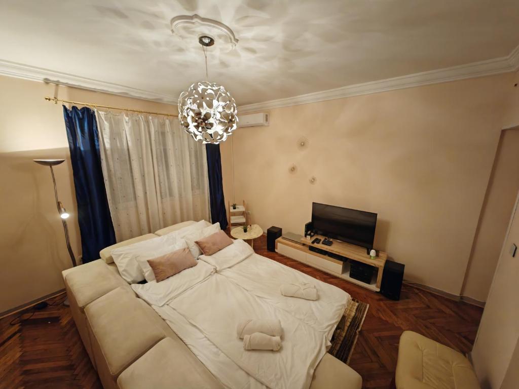 贝尔格莱德Stadion apartman的卧室配有一张白色大床和吊灯。