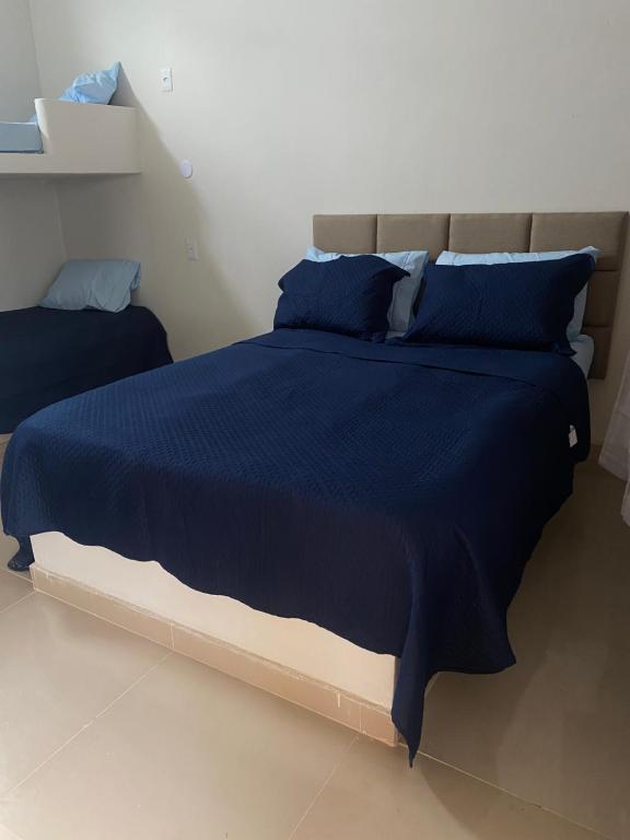 圣弗朗西斯科-迪伊塔巴波阿纳Pousada Casa da Praia SFI的一间卧室配有蓝色的床和蓝色枕头
