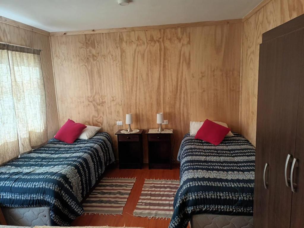 科伊艾科Ventisca Sur的一间卧室配有两张带红色枕头的床。