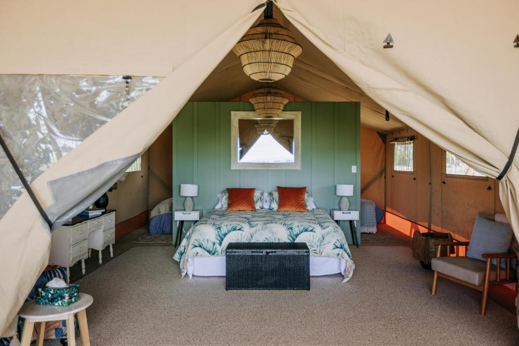 哈士汀Villas & Vines Glamping的帐篷内一间卧室,配有一张床