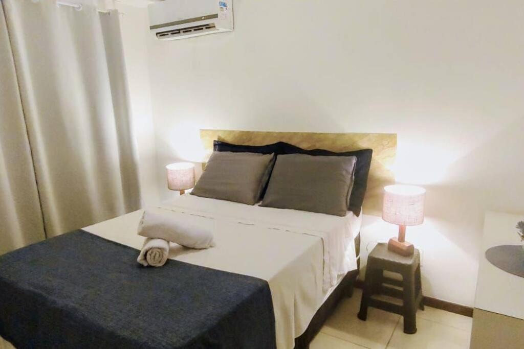 莫罗圣保罗Espaçoso apartamento a 50mt do mar的一间卧室配有一张大床和一个床头柜