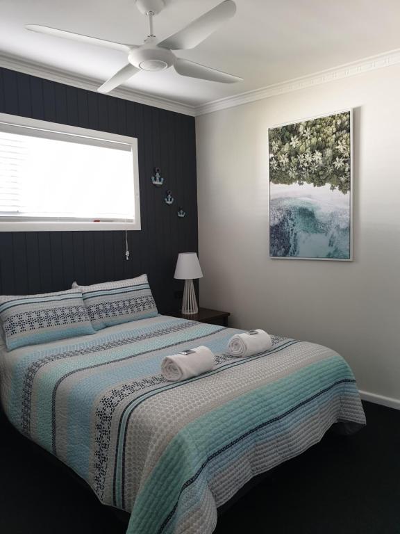 赫维湾Lisianna Apartments的一间卧室配有一张床和吊扇