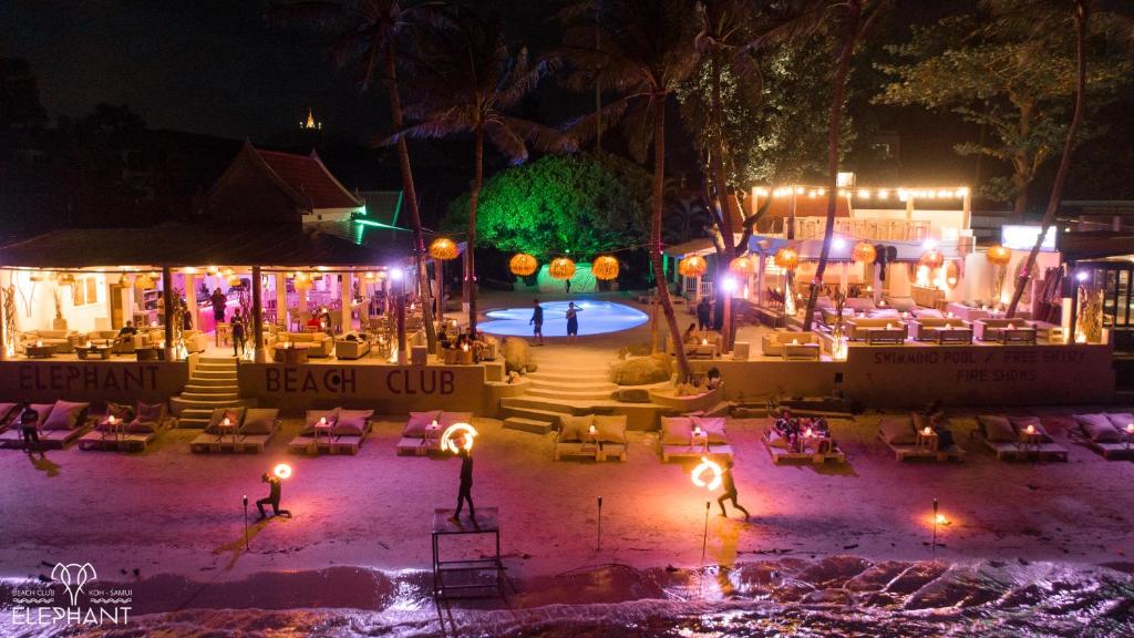 查汶Elephant Beach Club & Resort Samui的夜间海滩俱乐部,配有椅子和灯