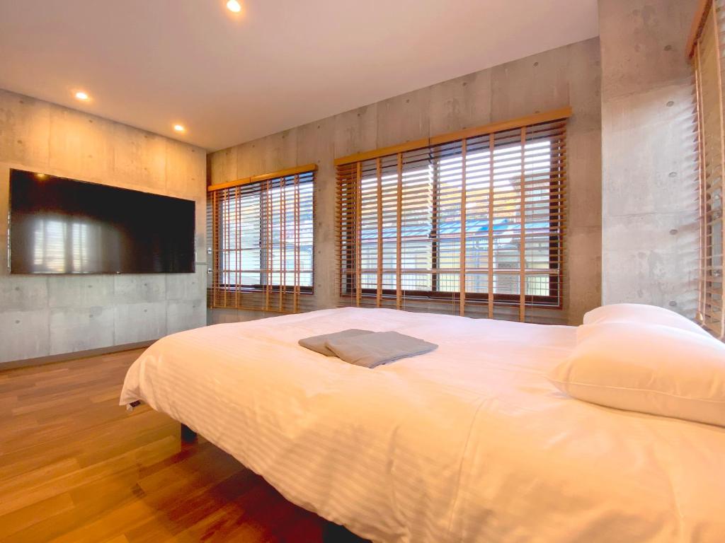 Mongawaさくらや旅館的一间卧室配有一张大床和一台平面电视