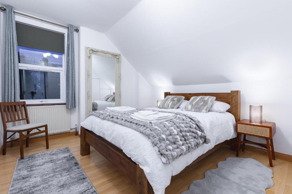 伊灵Cosy Flat In London的一间卧室设有一张大床和一个窗户。