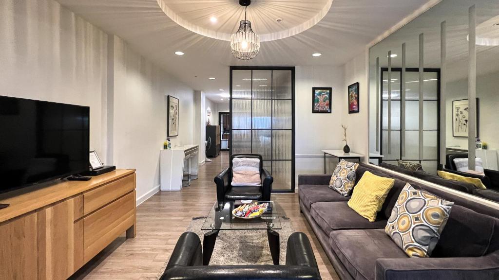 曼谷内维尤尊贵公寓：拉查达的带沙发和电视的客厅