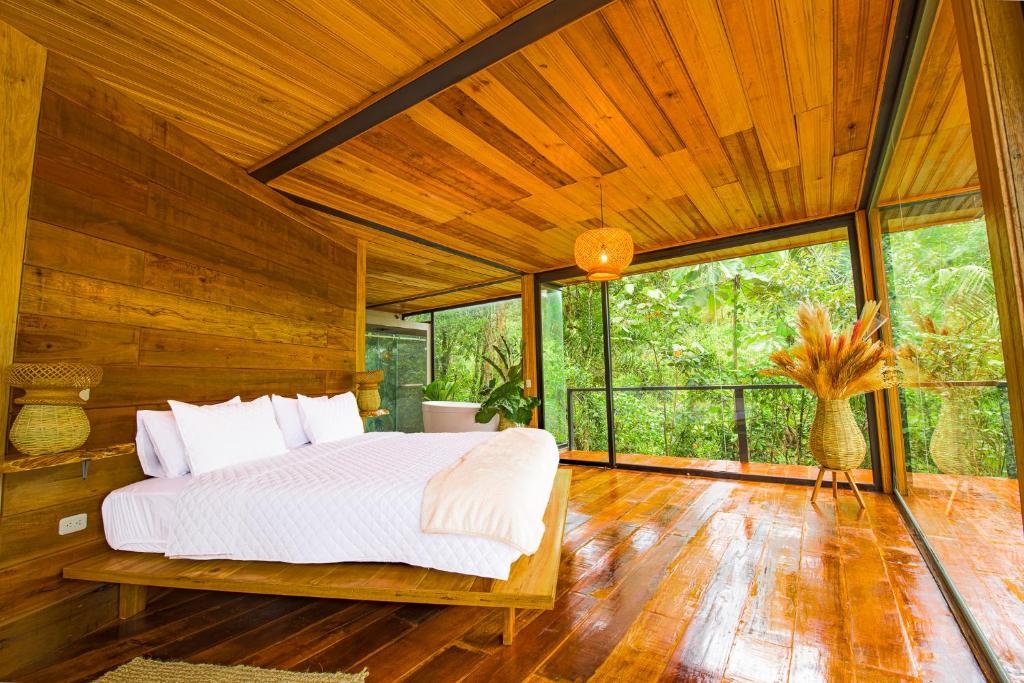 MeraCedro Amazon Lodge的一间带一张大床的卧室,位于带木墙的房间