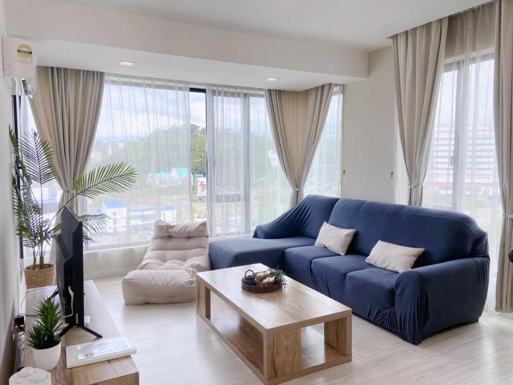 哥打京那巴鲁Sky Suite Kota Kinabalu-6 Pax-2Rooms-5MinsDrive-Imago,SuteraAve,Riverson,KKTimeSquare的客厅配有蓝色的沙发和茶几