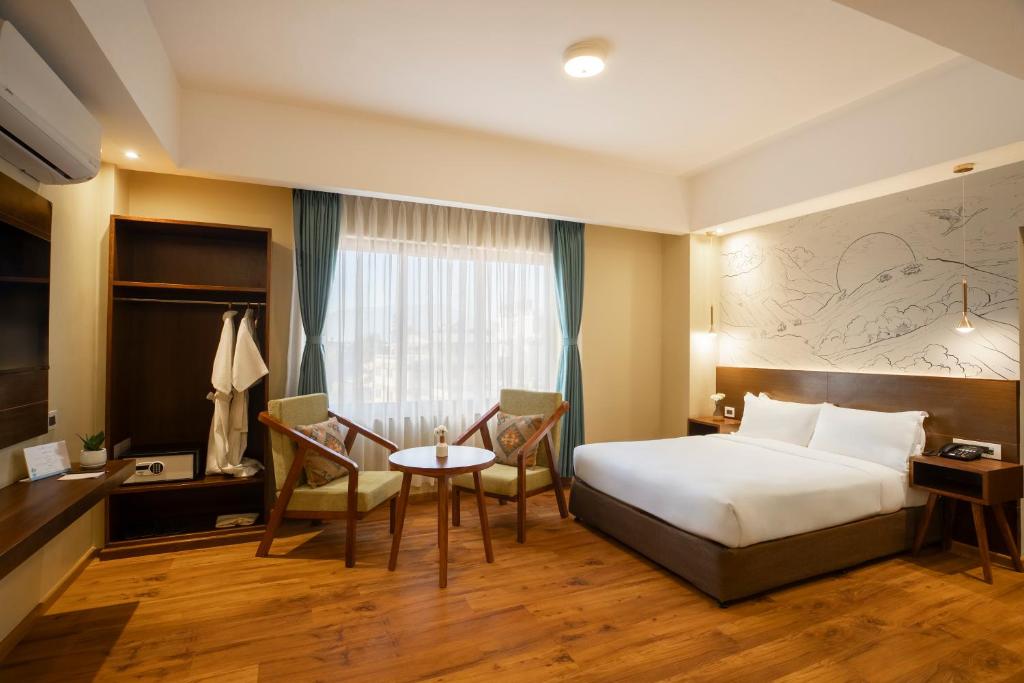 加德满都Atisha Hotel的酒店客房带一张床、一张桌子和椅子