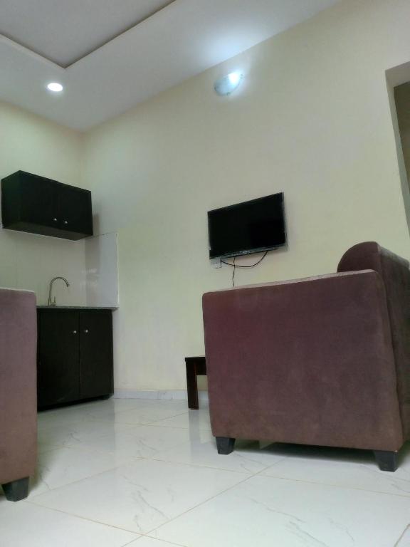 AbeokutaF&B Service Apartment的客厅配有2把椅子和平面电视