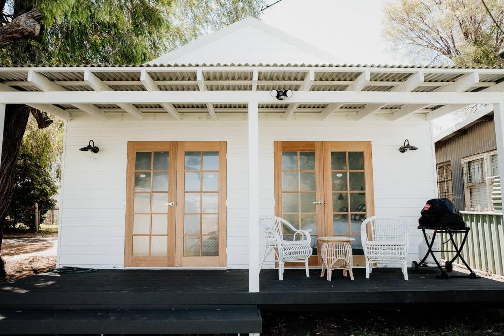 邓斯伯勒Sur Mer Studio - Seaside Escape的白色的房子,配有白色椅子和凉棚