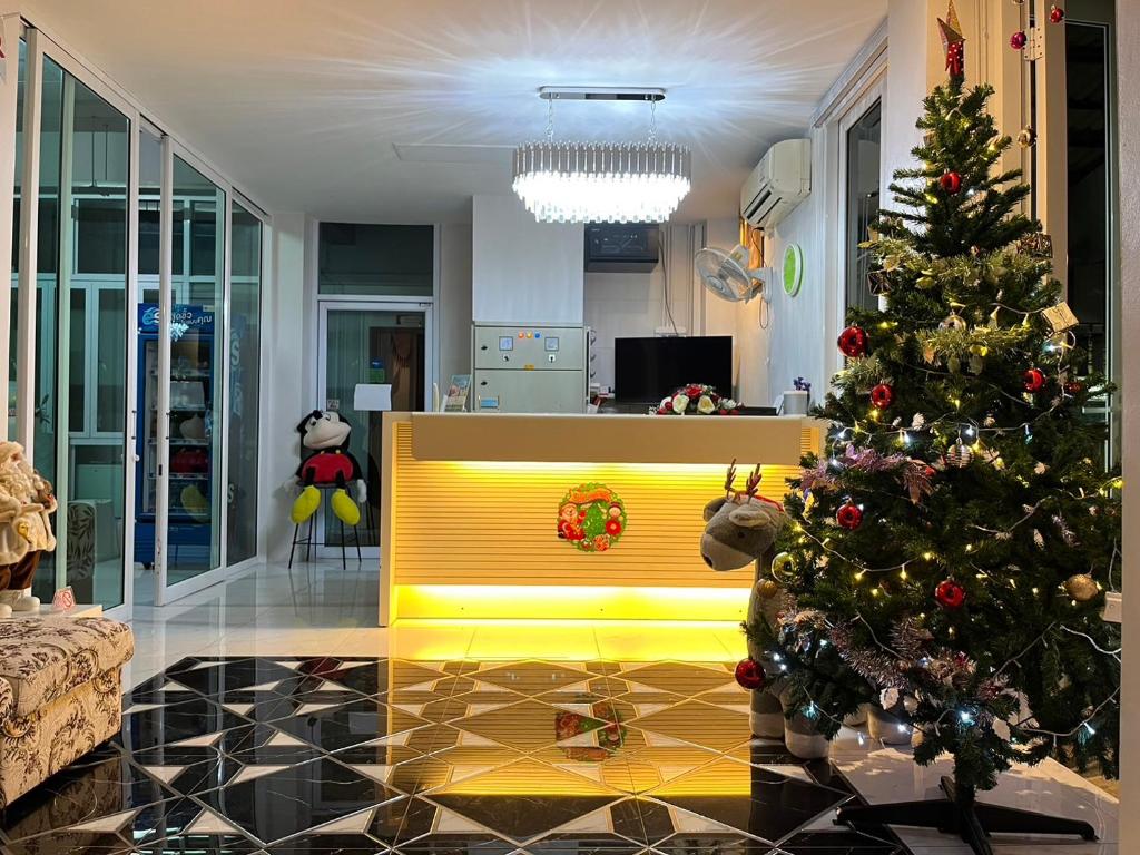素叻帕庞孔公寓的一间客厅,配有圣诞树和黄色长凳