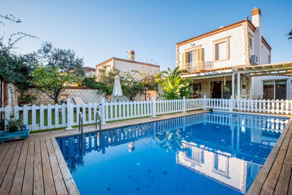 阿拉恰特Luxury Duplex Villa w Pool and Garden in Alacati的一座带白色围栏和游泳池的房子