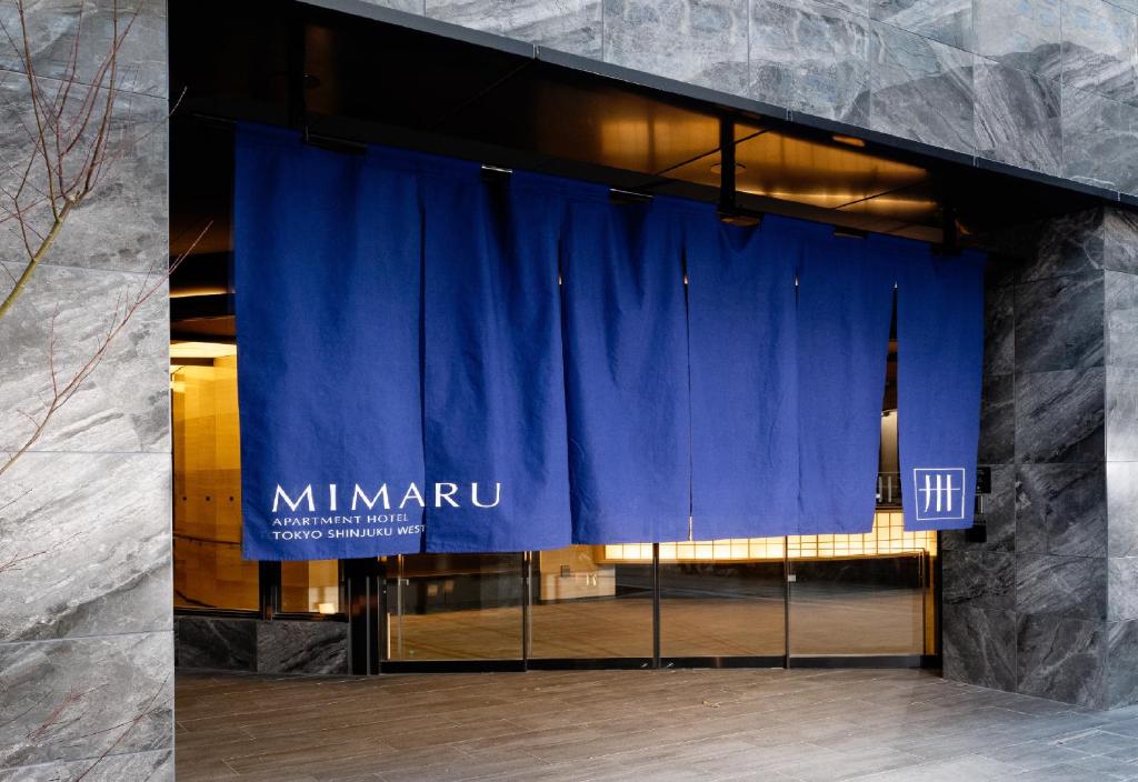 东京MIMARU TOKYO SHINJUKU WEST的建筑前的一块带蓝色窗帘的舞台