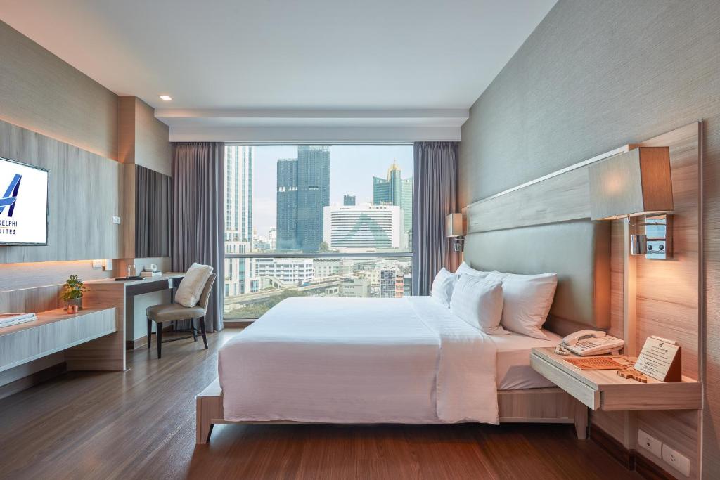 曼谷 和阿德尔菲套房的酒店客房设有一张大床和一张书桌。