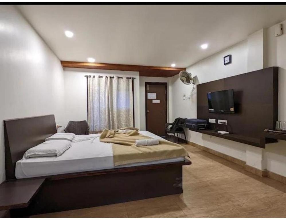 布莱尔港Sea Lounge, Port Blair的一间卧室配有一张大床和一台平面电视