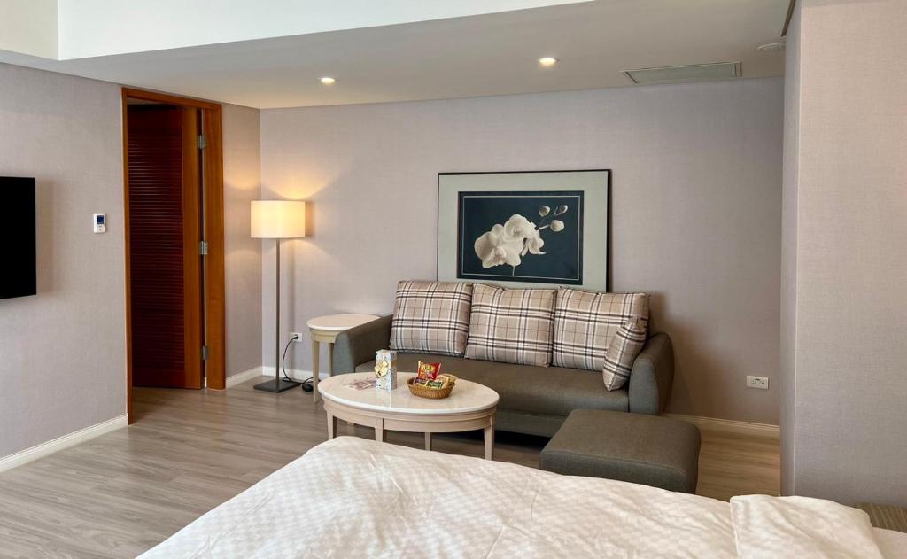 台北瑞昊國際商旅-家美瑞品-JiaMei Hotel的客厅配有沙发和桌子