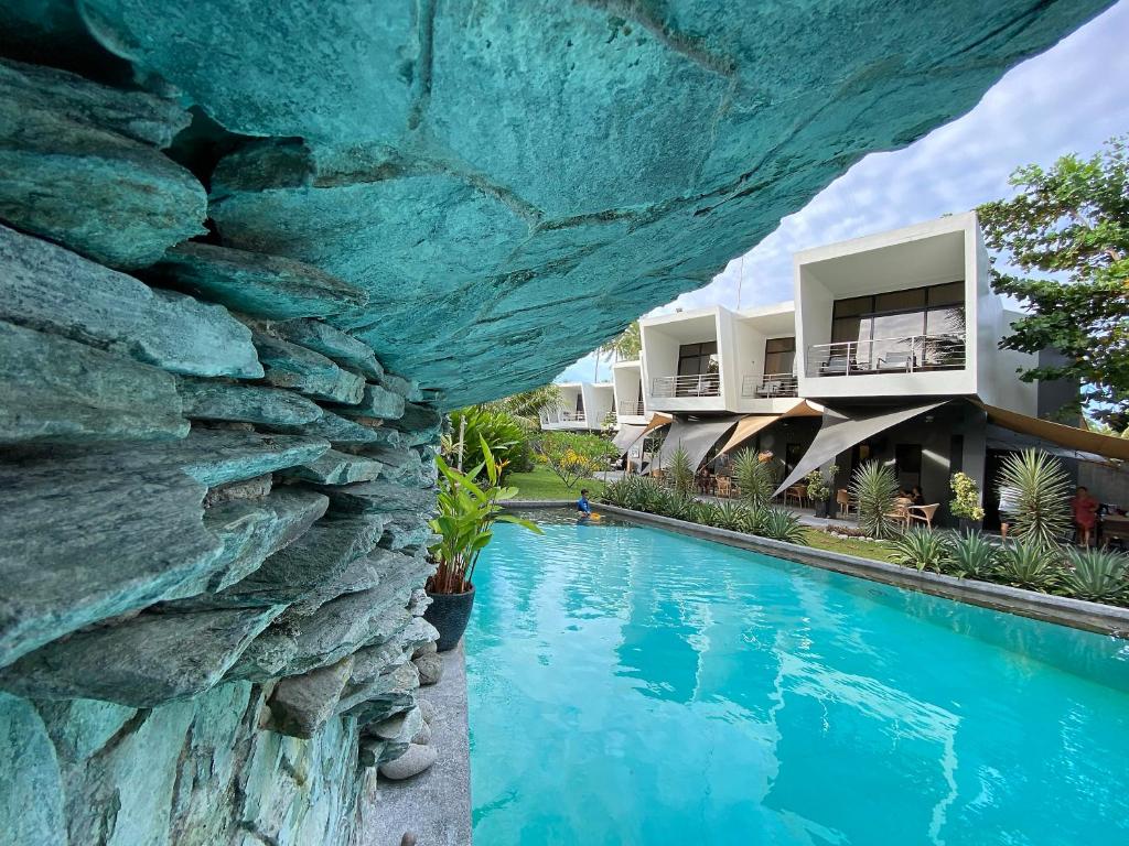 ZamboanguitaMahi Mahi Dive Resort的游泳池旁的带岩石墙的度假村