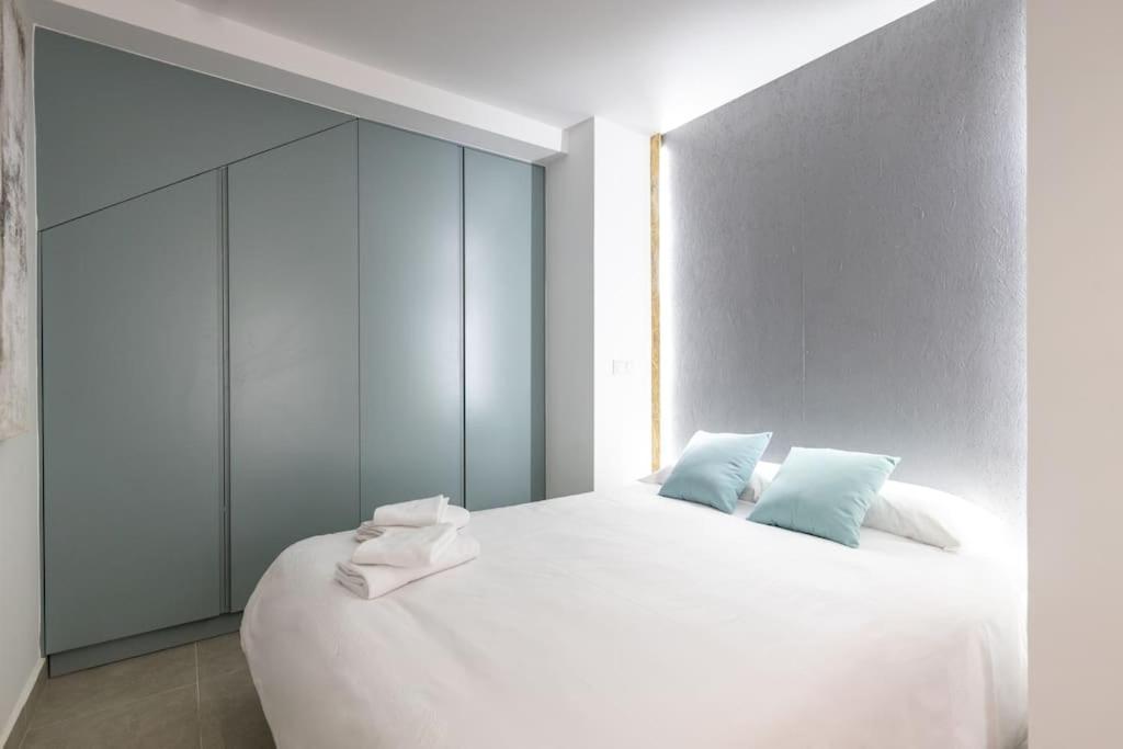 马德里Estudio moderno y acogedor en Madrid Rio nº4的卧室配有带蓝色枕头的大型白色床