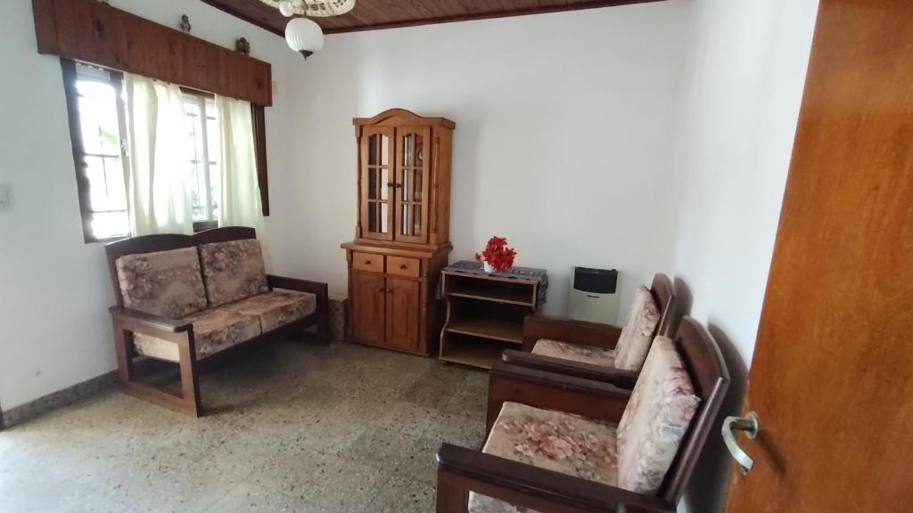 GualeguaychúLo de Silvia的客厅配有两把椅子和橱柜