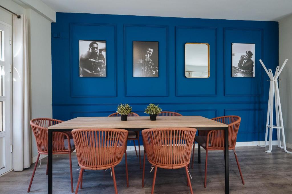 塞维利亚森特拉尔套房公寓的一间设有蓝色墙壁和桌椅的用餐室