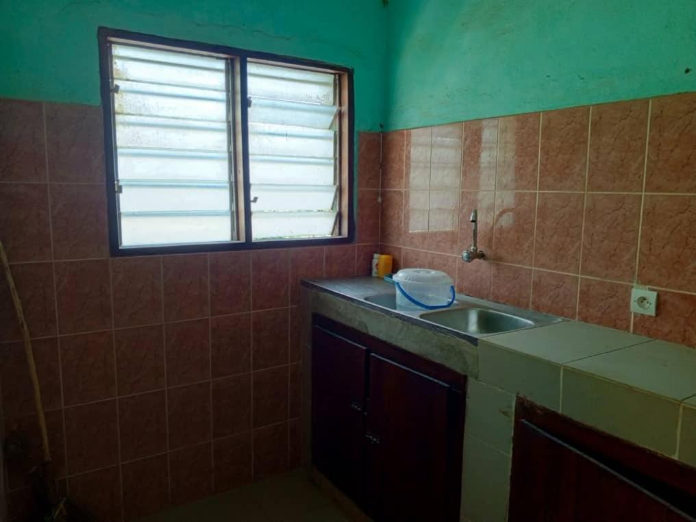 OuidahAppat'Adjanohoun的一个带水槽和窗户的小厨房