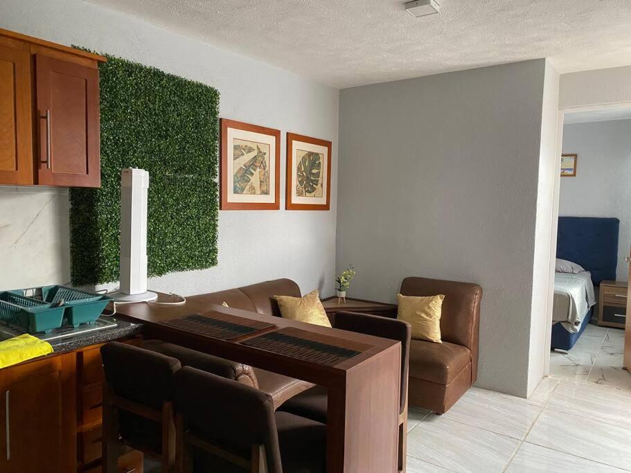 瓜达拉哈拉Casa duplex aeropuerto/arena VFG的客厅设有桌子和绿色的墙壁