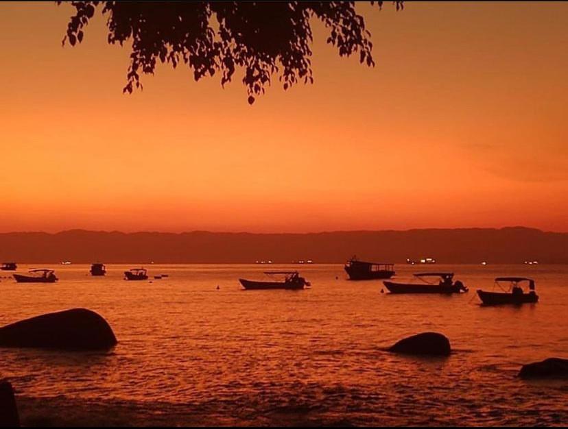 阿拉夏奇巴海滩Casa Quintal - Pé na Areia - Araçatiba Ilha Grande的日落时分在水中的小船
